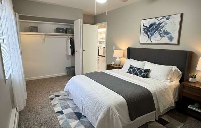 A bedroom with a bed, a ceiling fan, and a rug.