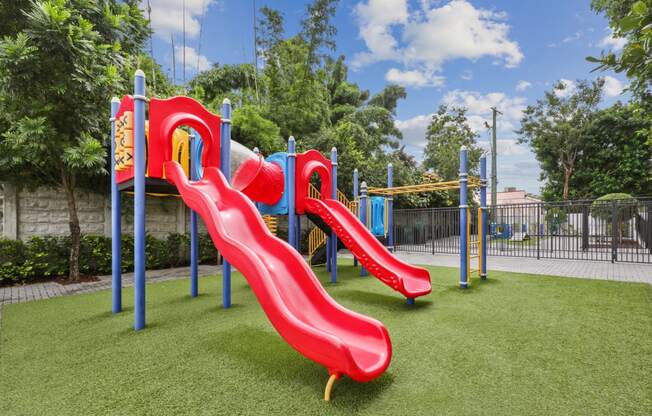 Red playground with slides at Bay Village 1 in Palmetto Bay, FL