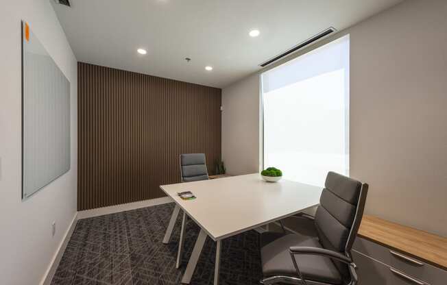 a meeting room with a white table and chairs