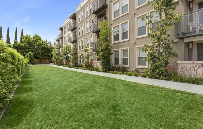 Studio Apartments in Redwood City CA - mResidences Redwood City - Tan Buidling Exterior with Grassy Lawn and View of Balconies