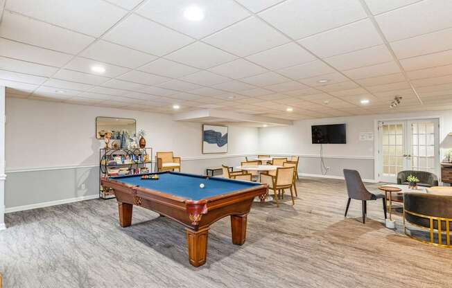A room with a pool table and a TV.