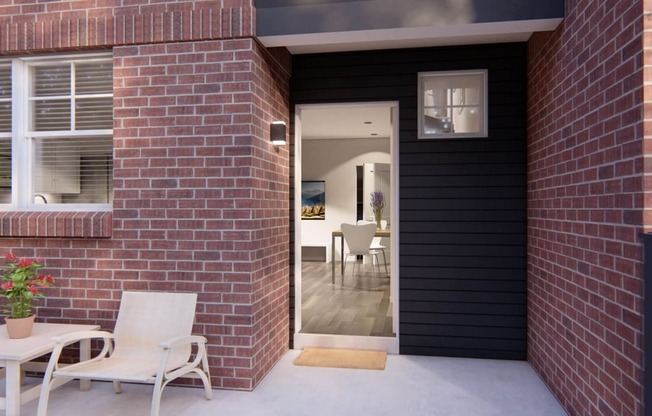 this house has a black exterior with a red brick wall at Brownstones at Palisade Park, Broomfield, CO