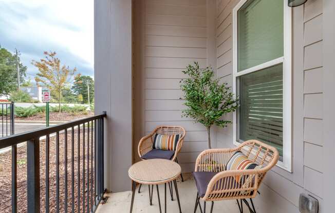 two chairs and a table on the porch of a house