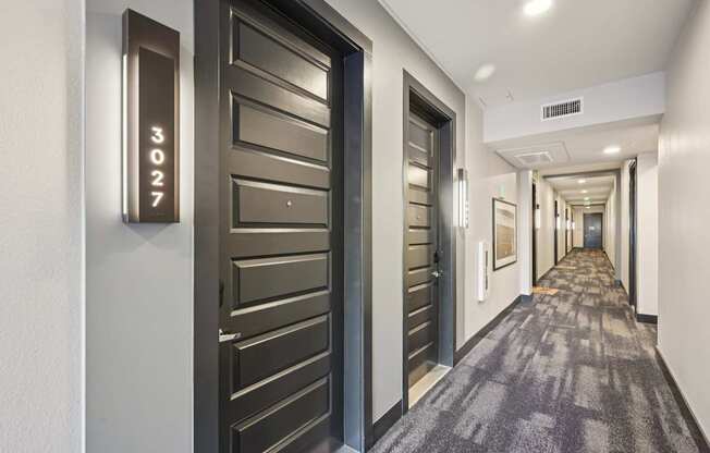 A hallway with doors numbered 3027.