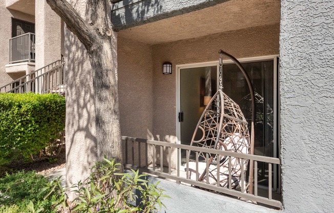 the front porch of an apartment building with a swing on it