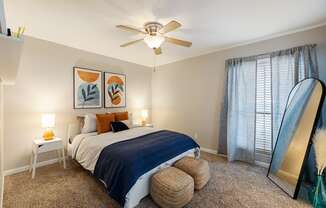 a bedroom with a large bed and a ceiling fan
