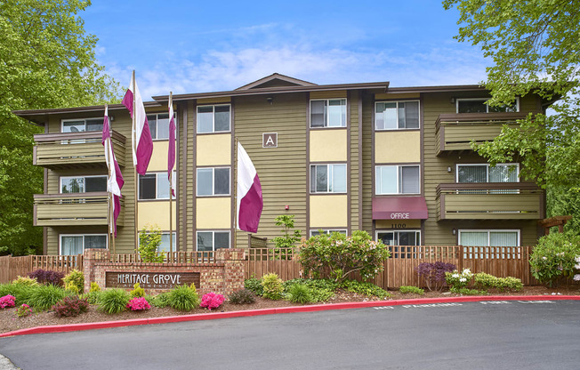 Exterior view of manicured grounds and building, and blue skies in the background at Heritage Grove, Renton, WA.