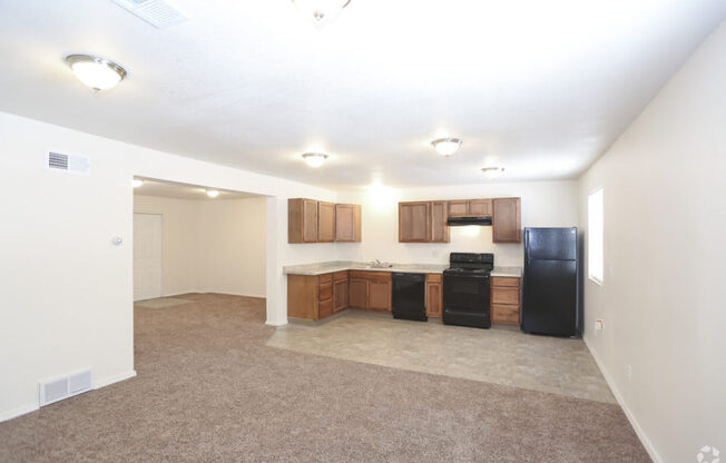 A kitchen with black appliances and brown cabinets.