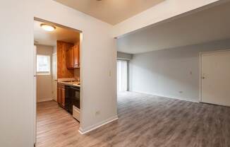 A room with a kitchen area and a dining table.