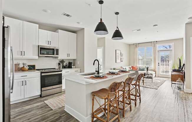 A modern kitchen with a large island and wooden chairs.