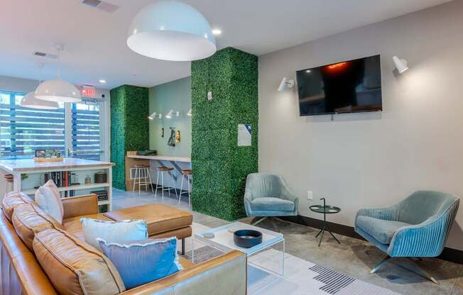 A living room with a green wall and a flat screen TV mounted on the wall.
