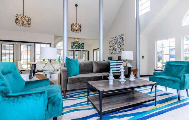 a living room with blue chairs and a gray couch at The Davis Apartments, Huntsville, AL  