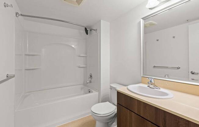 A white bathroom with a toilet, sink, and bathtub.