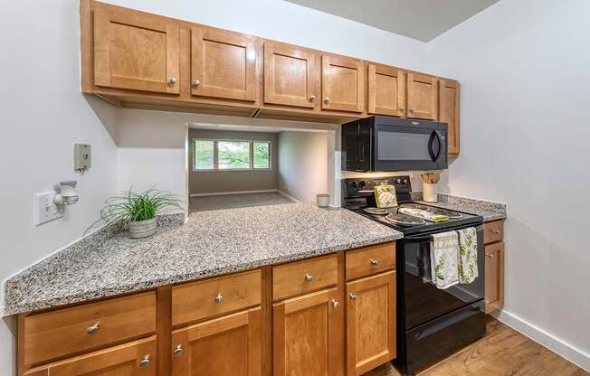 A kitchen with granite countertops and wooden cabinets.