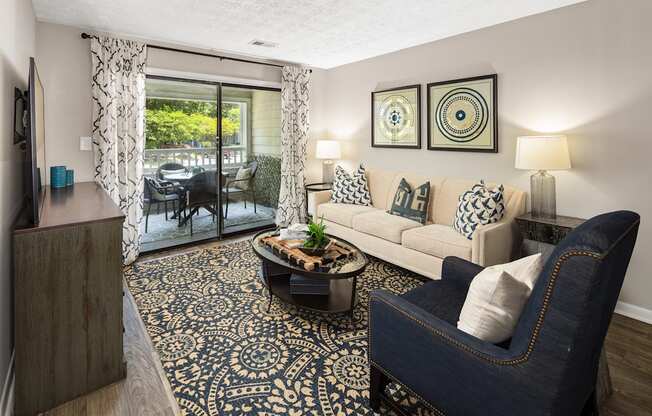 A living room with a blue chair and a patterned rug.