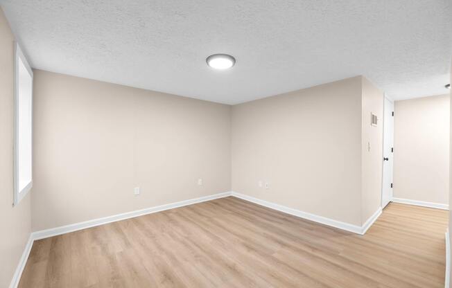 A room with wooden flooring and a ceiling light.