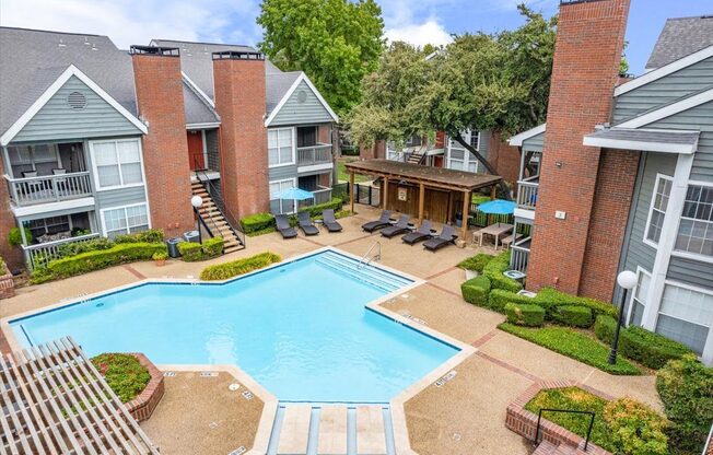 an aerial view of a swimming pool in front of an apartment building