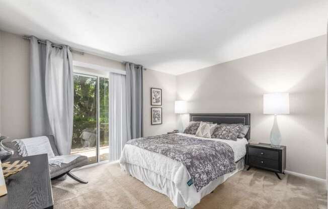 A bedroom with a large bed and a window with curtains.