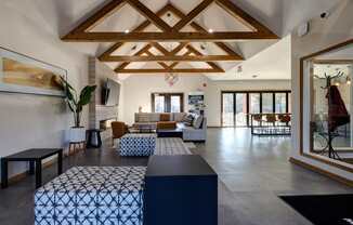 A living room with a wooden ceiling and a large window.