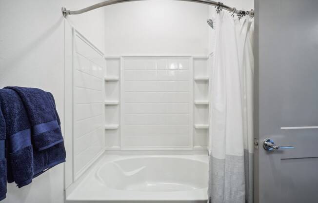 a small white bathroom with a shower and a tub