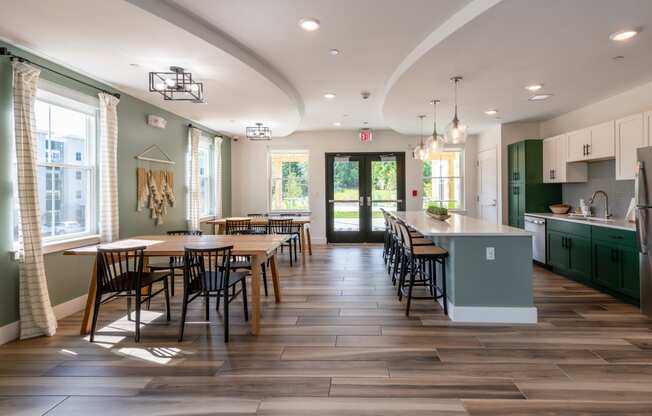 a clubroom kitchen with a large table and chairs at Edgebrook Residences, Merrimack