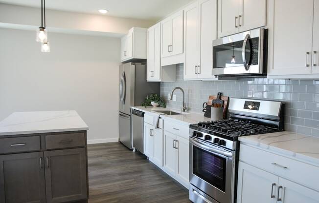 a kitchen with white cabinets and stainless steel appliances