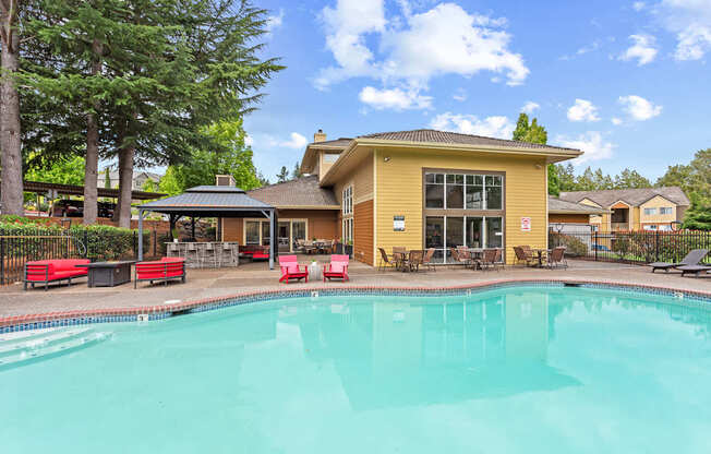 A yellow building with a pool in front.