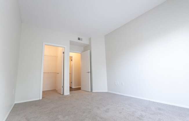 an empty living room with white walls and carpet