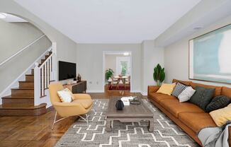 A living room with a brown couch, a yellow chair, and a TV.