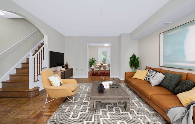 A living room with a brown couch, a yellow chair, and a TV.