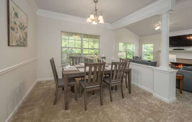 A dining room with a table and chairs.