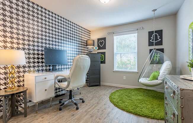 a bedroom with a desk and a chair and a hanging chair in front of a window