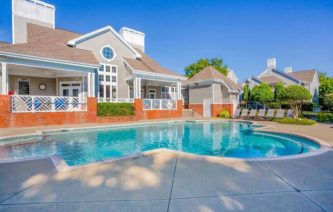 A house with a pool in front of it.