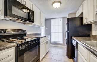 Westchase Apartments in Harvey LA photo of a kitchen with black appliances and white cabinets