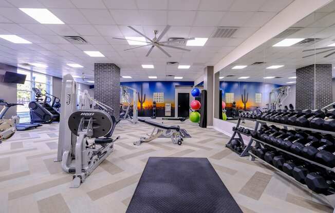 fitness center with weights and cardio machines at Roosevelt Square apartments