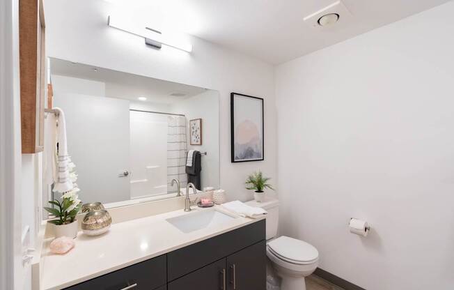A bathroom with a white sink and a white toilet.