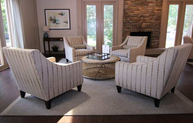 Four striped chairs are arranged around a coffee table in a living room.