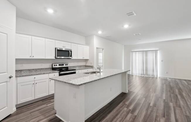 kitchen with marble countertop and white cabinets within a spacious living area
