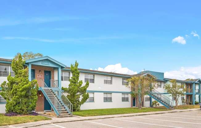 an exterior view of an apartment building with a parking lot