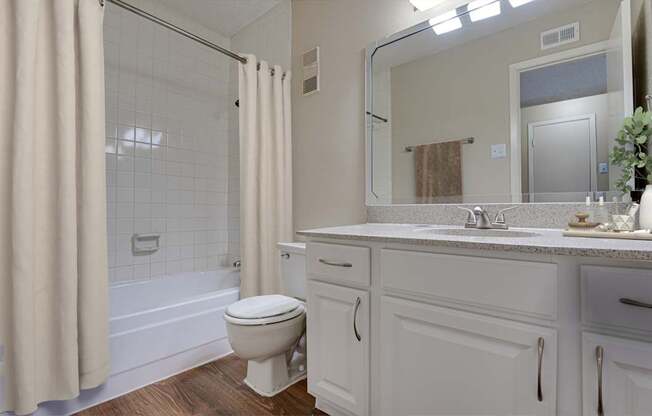 A white bathroom with a toilet, sink, and shower.