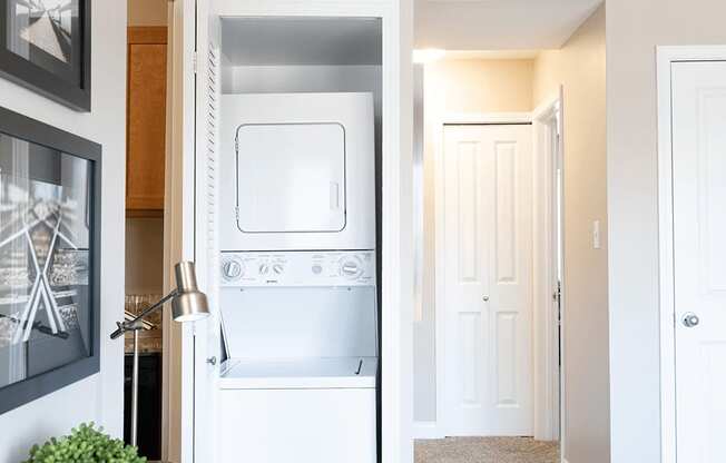 an in-home laundry room with a washer and dryer and a closet with a door