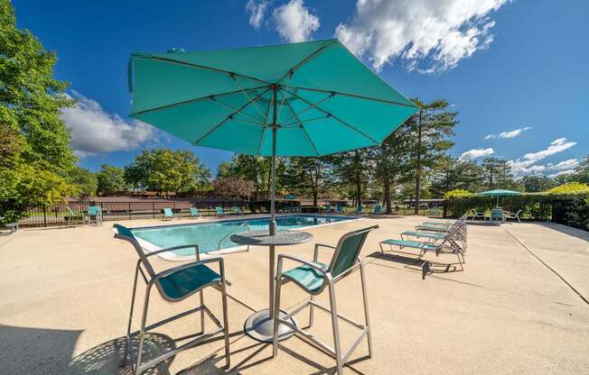 Heated pool equipped with comfy lounge chairs at Westwood Village Apartments in Westland, MI