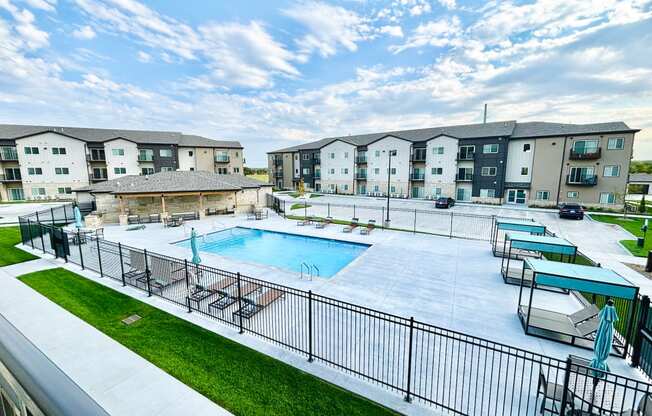an outdoor swimming pool with apartments in the background