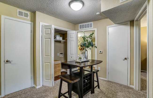 A small dining area with a table and chairs.