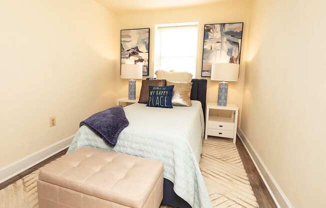 A bedroom with a bed, nightstand, and chair.