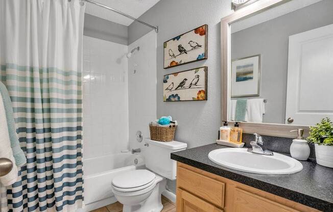 Bathroom with a soaking tub, curved shower curtain rod, and sink
