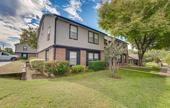A modern two-story house with a well-maintained lawn in front.