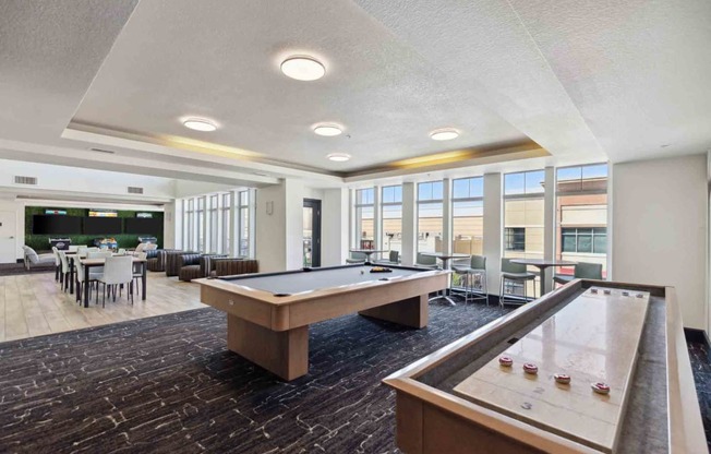 a community room with a pool table and a dining area