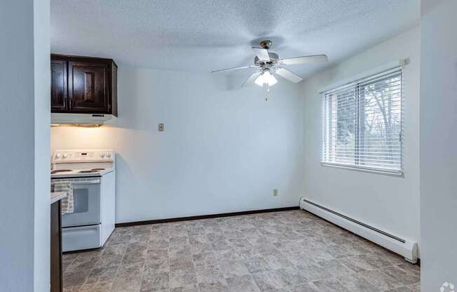 A kitchen area with a stove and a fan.