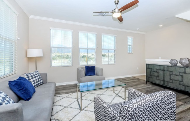 a living room with couches and a glass coffee table